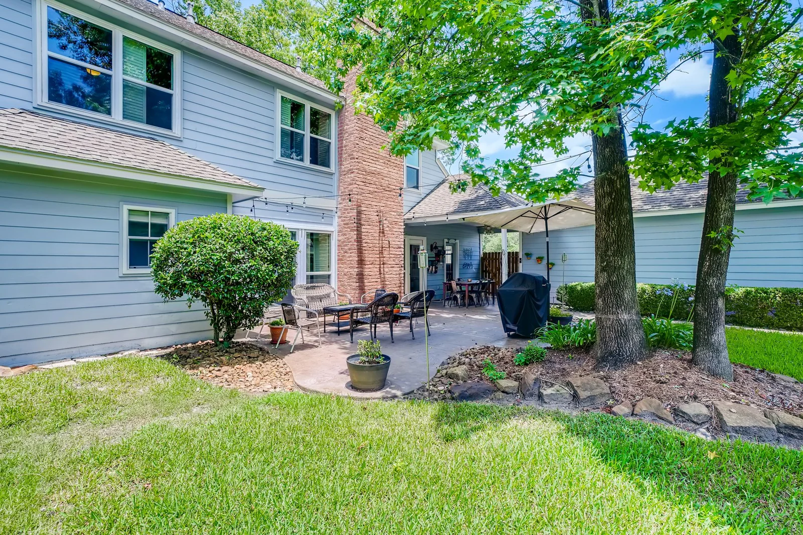 The tree-shaded backyard and patio photograph used in the live Verdant concept