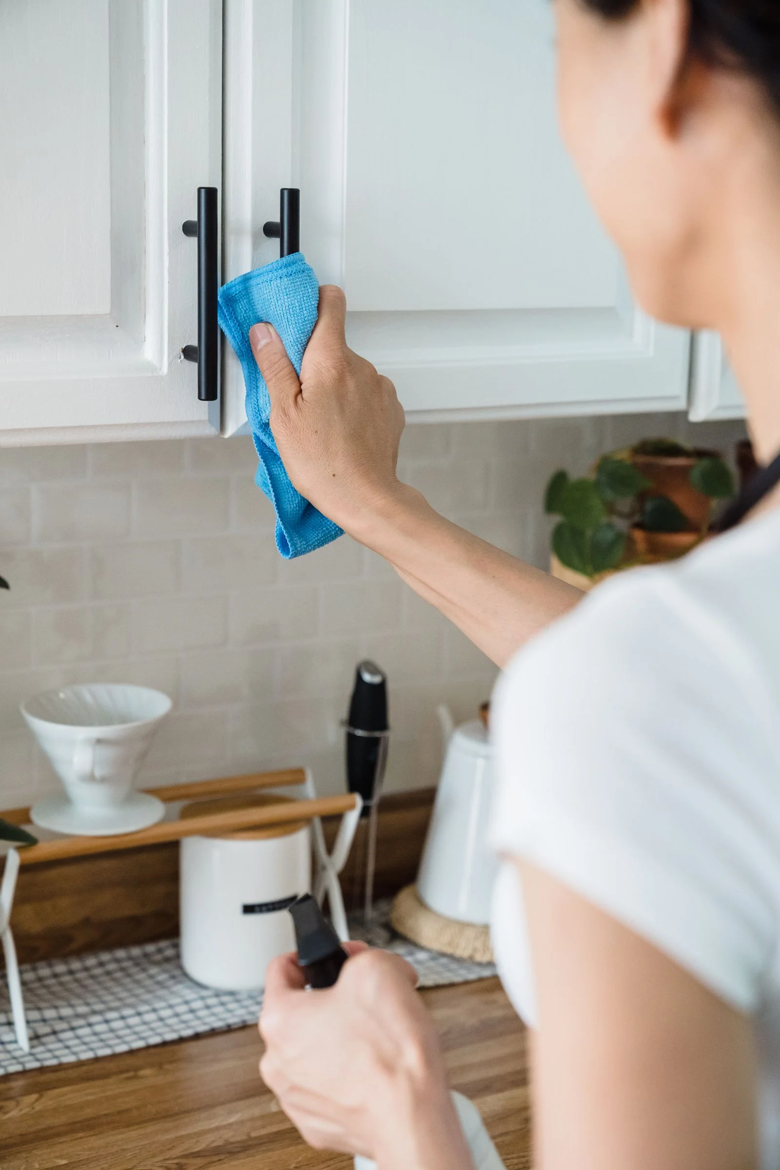 A person carefully wiping a kitchen cabinet, from the real Brighthouse concept photography