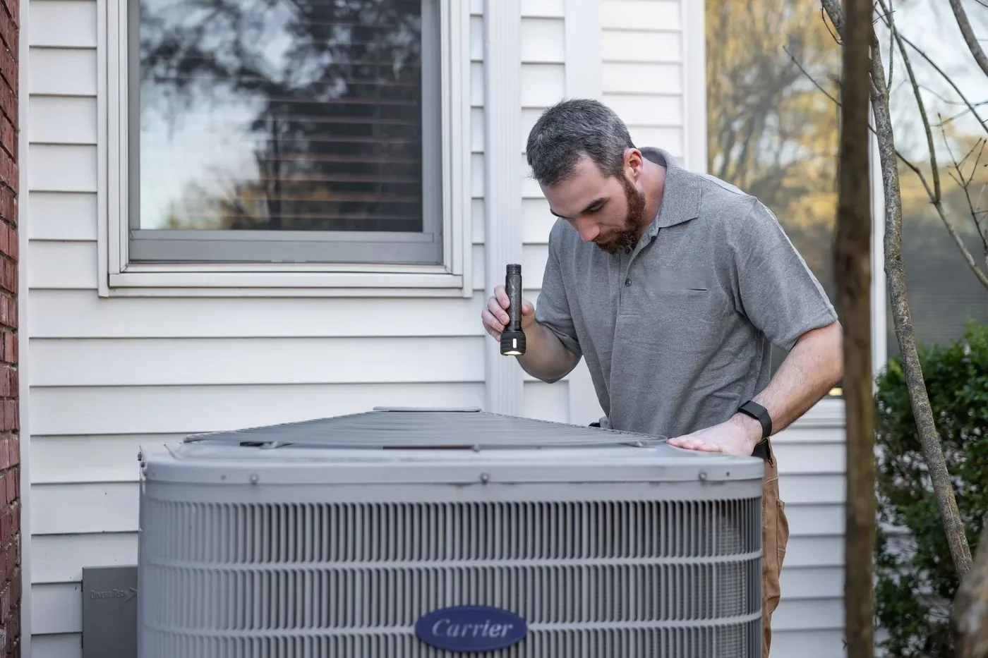 Technician inspecting a residential outdoor air conditioner, from the actual Northline concept photography